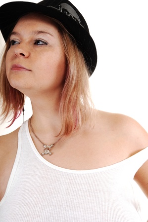 A young blond woman in an undershirt and a black hat on white background.の写真素材