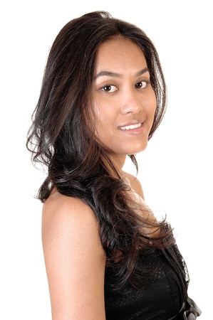 Beautiful smiling Asian girl in a profile portrait shoot with her longcurly brunette hair, looking into the camera, on white background.の写真素材