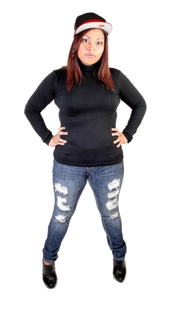A young Hispanic woman in ripped jeans, an black sweater, boots and abasket ball cap, standing for white background with her red hair.の写真素材