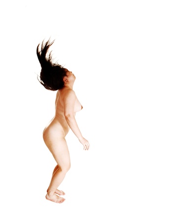 A pretty nude Asian woman dancing in the studio and playing with herlong black hair, seeing from the side for white background の写真素材