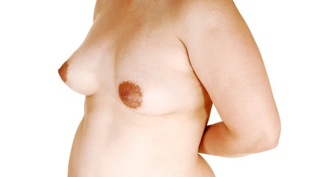 A young topless Asian woman standing in the studio for white background,showing her gorgeous breasts in a closeup の写真素材