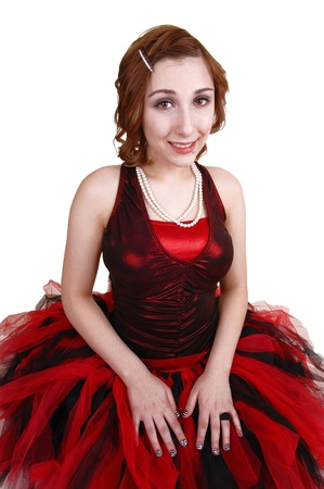 A teenage girl in an red and black ballet outfit kneeling on the floor,looking up into the camera, for white background の写真素材