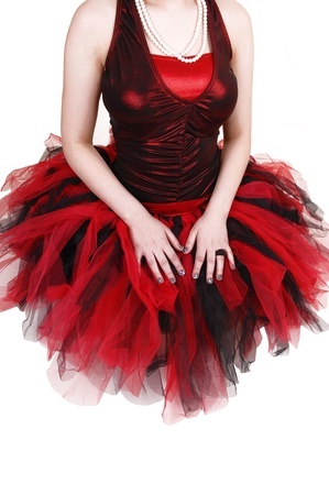 A body shot of a young ballerina girl in a red and black dress, kneelingon the floor for white background の写真素材
