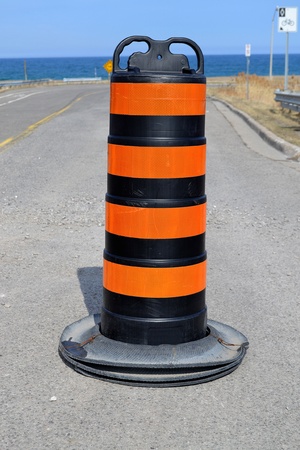 A single traffic pylon blocking a street in Stoney Creek, Ontario on theshores of lake Ontario, in beautiful sunshineの写真素材
