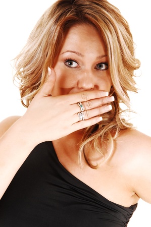A closeup shoot of a very surprised blond woman, holding herhand for her mouth, looking upset, for white background の写真素材
