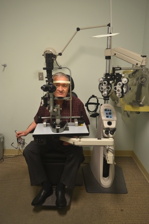 A older man sitting in the office of an optometrist checking out hiseyesight の写真素材