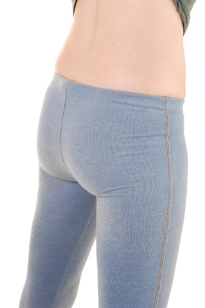 The backside of a young slim woman in blue thighs taking off her t-shirtshowing her nice butt in a closeup for white background の写真素材