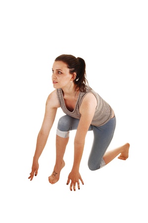 A young skinny woman is in start up position in the studio in bare feetand blue thighs for white background の写真素材