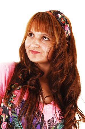 A portrait shot of a young woman with bright red hair and a pink topfor white background, looking up の写真素材