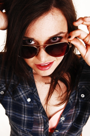 A young pretty girl in closeup, wearing sunglasses and a sheckered shirt and pink bra, looking into the camera の写真素材