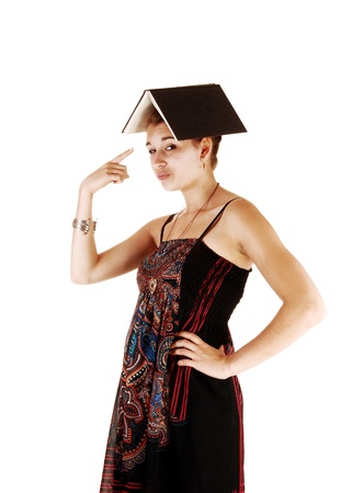 A portrait picture of a student in a dress and an book on her head, for whitebackground and pointing with her finger at the book の写真素材