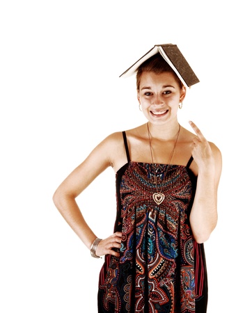 A portrait picture of a student in a dress and an book on her head, for whitebackground and pointing with her finger at the book の写真素材