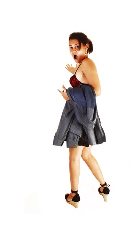 A pretty young woman leaving her job in high heels, black skirt, a greenjacket over her arm, very spruced, and a black red bra over white の写真素材
