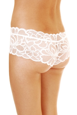 The behind of a slim young woman in white lingerie lace panties standingfor white background, showing her nice round buttocksの写真素材