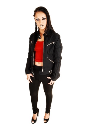 A young teen girl in black tights and a red top and a black jacket, with long black hair standing for white background, with black lips の写真素材