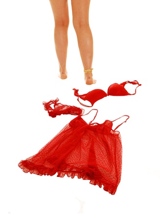 A young woman taking of her red lingerie underwear and walking awayfrom it, for white background の写真素材