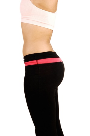 A picture of the butt of a young woman in black exercise pantsstanding in profile on white background の写真素材
