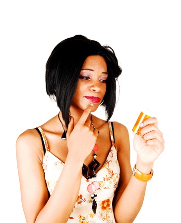 A young woman is sceptic if she should take these pills or not, portraitfor white background の写真素材