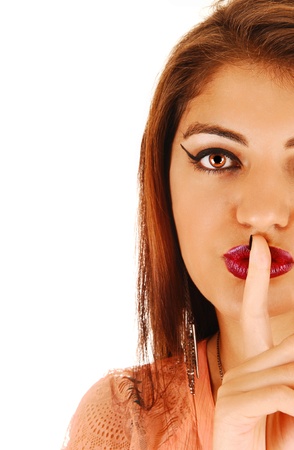 The half face of a gorgeous young woman with one finger over hermouth, for white background の写真素材