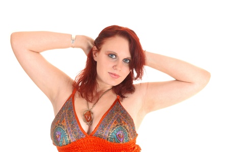 A closeup picture of a pretty teen girl with red hair in a colorful dresswith her hands behind her head, for white background の写真素材