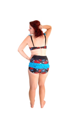 A young teen girl in an old fashion bikini standing from the back, bare feeton white background の写真素材
