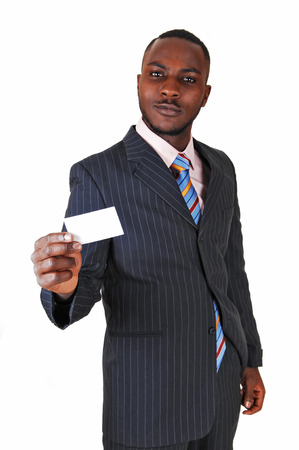 A young black business man standing in a suit and tie, holding up abusiness card for white background の写真素材