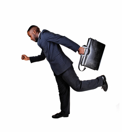 A black business man with his briefcase is running for white backgroundin a blue suit の写真素材