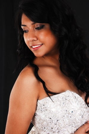 A closeup picture of a Hispanic young woman with long black hair standingfor black background in a wedding dress の写真素材