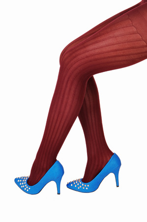 The sexy long legs of a young woman in burgundy pantyhose andblue high heels for white background の写真素材