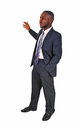 A young black business man standing in a suit and tie, holding up his hand on white background の写真素材