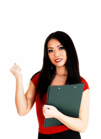 A beautiful young slim Asian business woman in red sweater andlong black hair standing for white background の写真素材