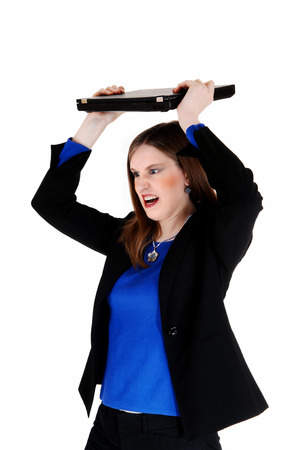 A young business woman in a black suit throwing her laptop very angry,for white background の写真素材