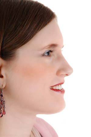 A closeup picture in profile of a young woman with brunette hairfor white background の写真素材