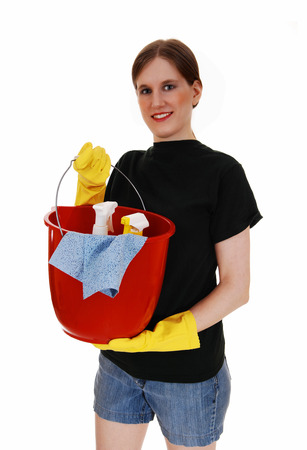 A young woman in shorts and yellow rubber cloves holding up an redbucket ready for cleaning, for white background の写真素材