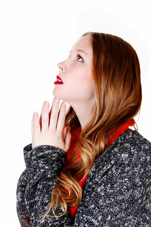 A lovely young woman standing in profile with her hands folded, praying,isolated for white background の写真素材