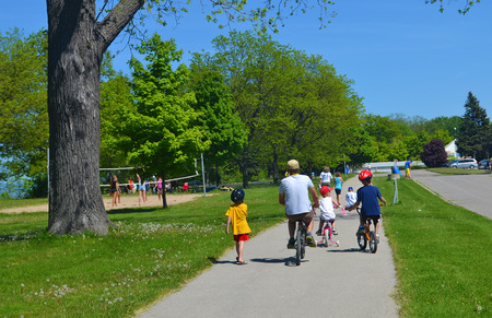 A family and little kids on bikes in a park in the spring の写真素材
