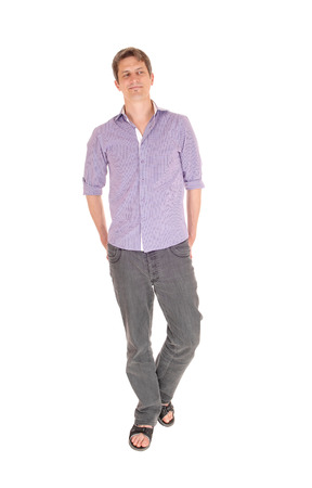 A young man in jeans and a purple shirt standing relaxed isolated
for white background.の写真素材