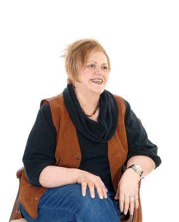 A lovely senior citizen woman in a brown vest sitting in an old armchairrelaxing, isolated for white background.の写真素材