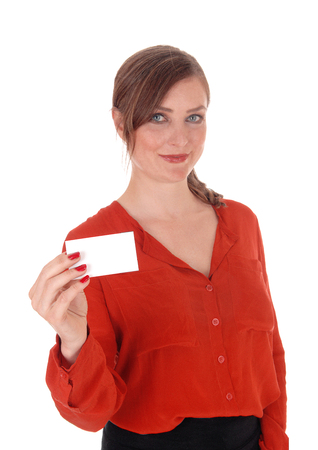 A beautiful woman in a red blouse and brunette hair holding an empty
business card up, smiling, isolated for white background.の写真素材