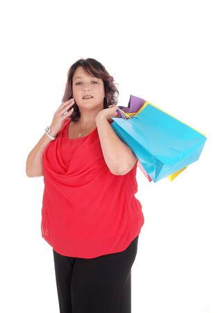 A woman in a red blouse holding her shopping bags standing
isolated for white background
の写真素材