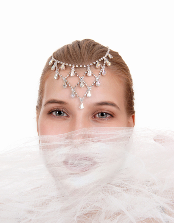 Beautiful young woman in close up with twill over her mouth and
jewellery on her forehead, isolated for white background
の写真素材