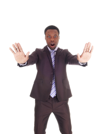 An African business man holds his hands up and mouths open and
says NO, don't do this, isolated for white background
の写真素材