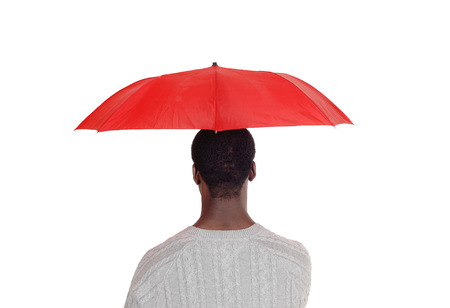 A closeup image of a African man standing from his back and holding
a red umbrella over his head, isolated for white background
の写真素材