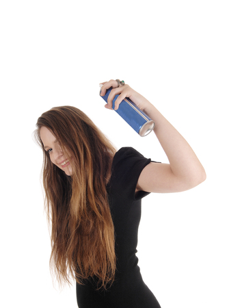 A lovely young woman spraying hair spray on her long brunette hair
smiling, isolated for white background
の写真素材
