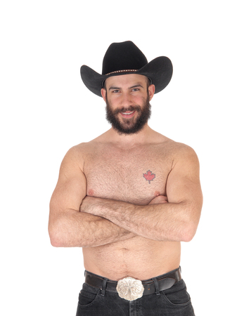 Young man standing shirtless, wearing a black cowboy hat and blackjeans with his muscular body, isolated for white backgroundの写真素材
