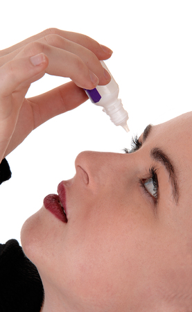 A close up image of a young woman putting eye drops is her dry eye
white open eyes, looking up, isolated for white backgroundの写真素材