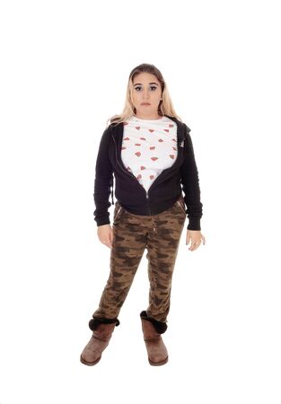 A young beautiful woman standing in camouflage pants and a black
sweater and boots isolated for white backgroundの写真素材