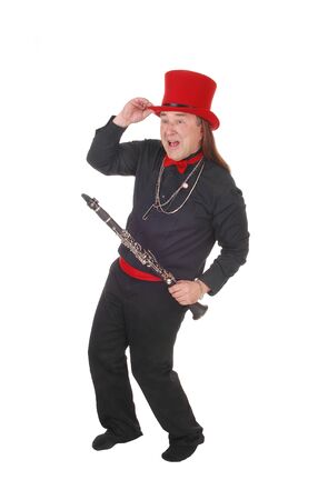 A indigenous man in a black shirt and pants and red hat dancing withhis clarinet in his hand, isolated for white backgroundの写真素材