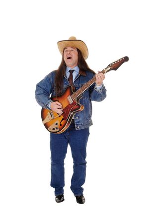 A handsome indigenous man in a jeans jacket, pants and a cowboy hat
standing and playing the guitar, isolated for white backgroundの写真素材