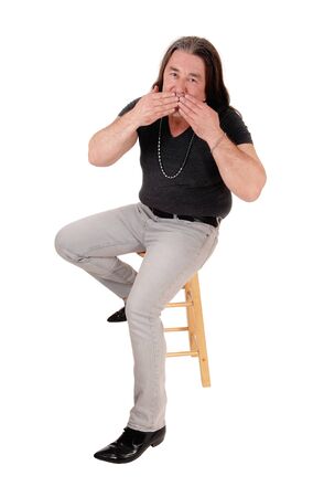A image of a middle age indigenous man sitting on a chair
and blowing a kiss, isolated for white backgroundの写真素材